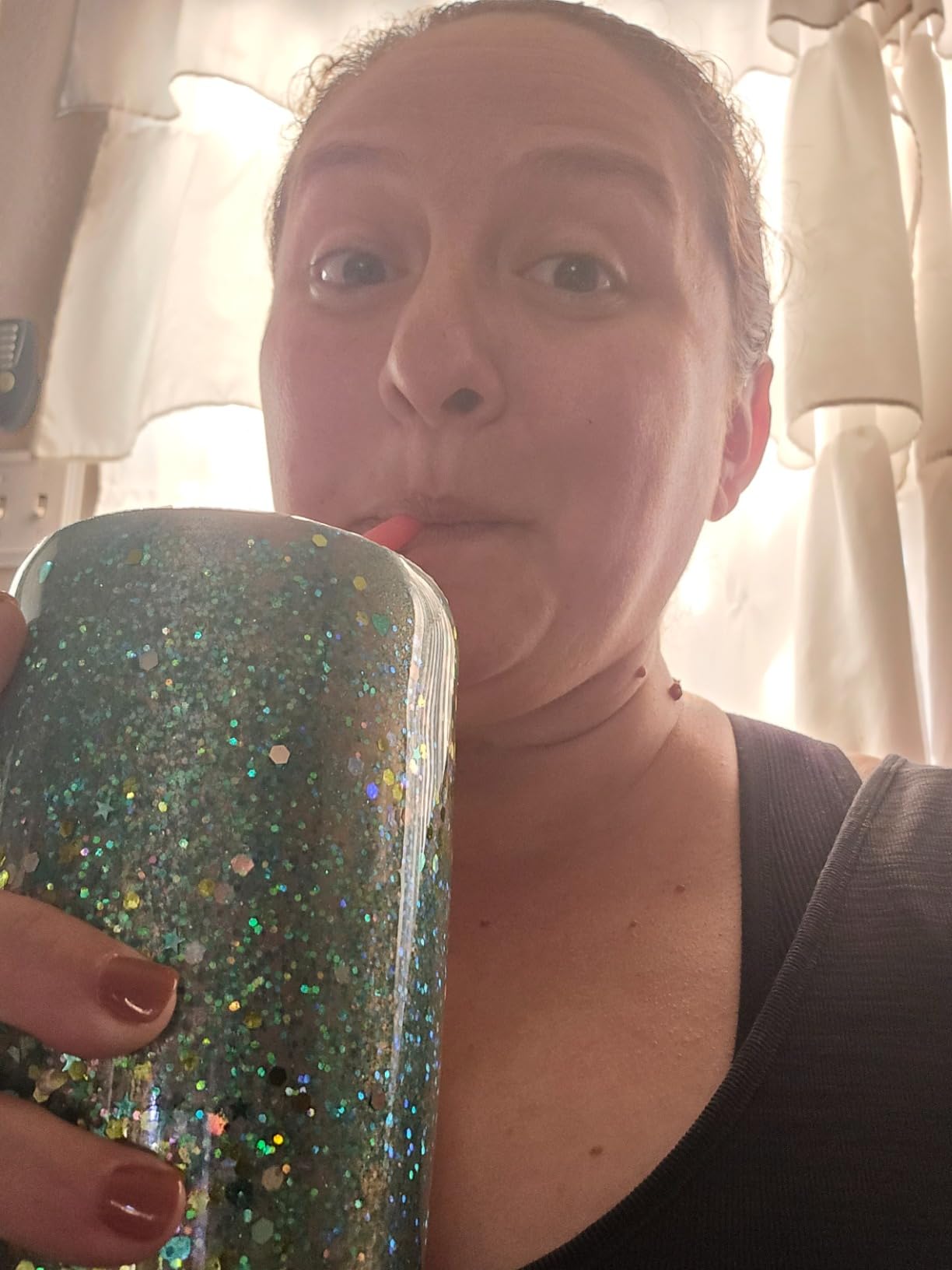 Smiling customer enjoying a glitter tumbler filled with a pink Tavo LiquidCalm liquid calm drink.