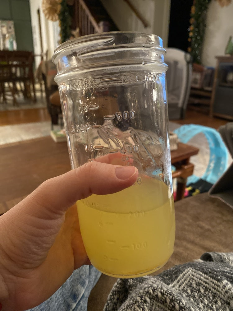 Iced yellow Tavo LiquidHydrate liquid hydrate drink in a mason jar outside on a sunny day.